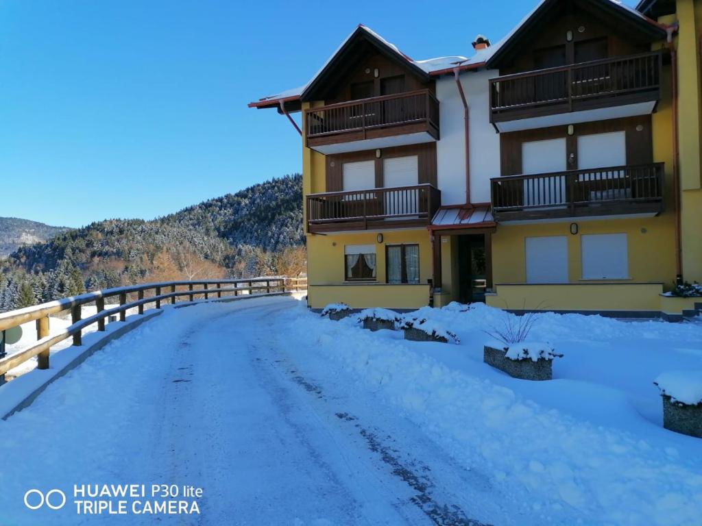 eine Straße vor einem Haus im Schnee in der Unterkunft APPARTAMENTO AL Sasso in Andalo