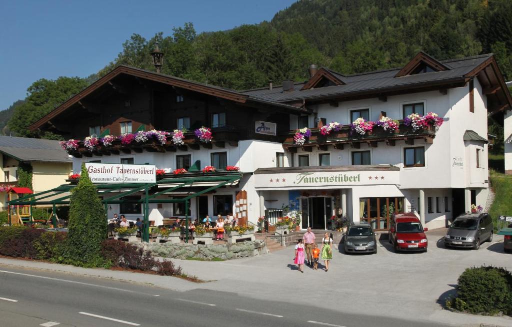 een groep mensen die voor een gebouw lopen bij Alpenhotel Tauernstüberl in Zell am See