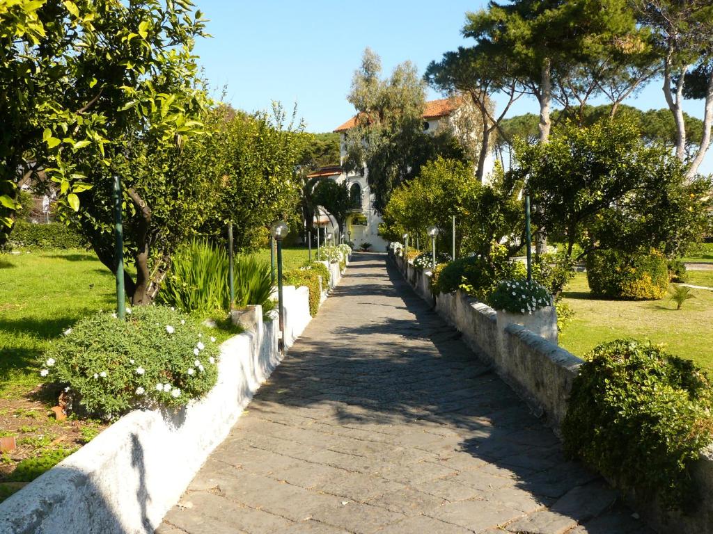 un sentiero in mattoni in un parco con alberi e cespugli di B&B Casa Maria Vittoria a Torre del Greco