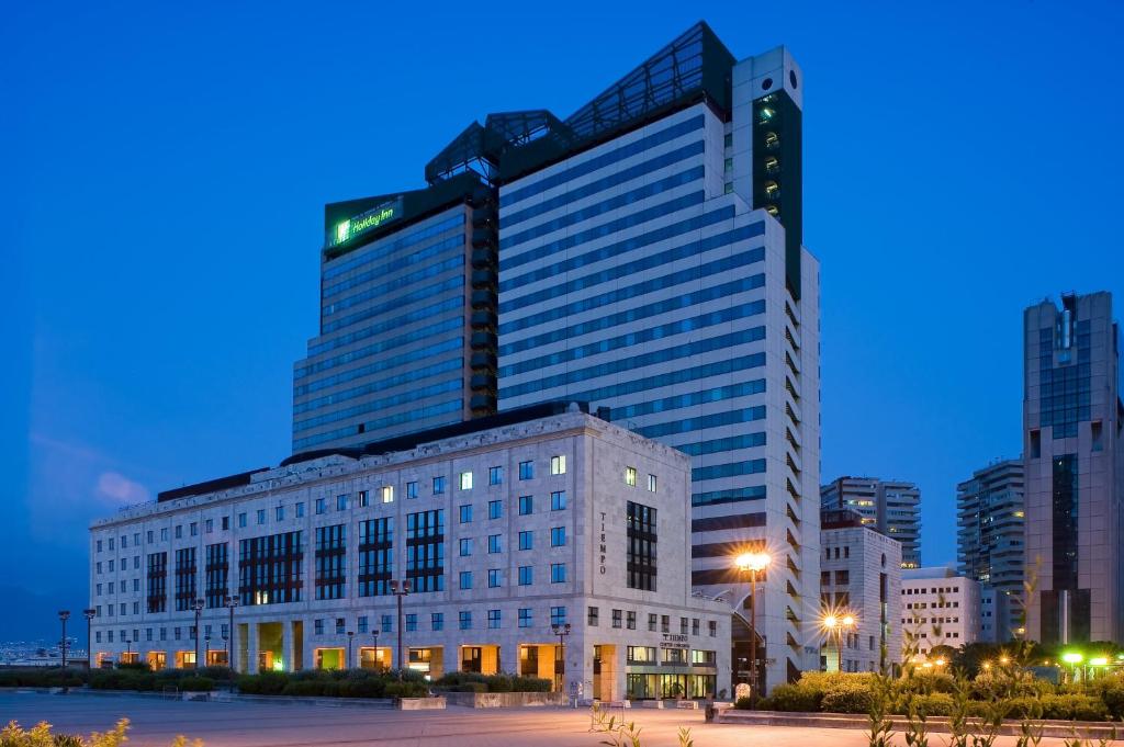 a large building in a city at night at Holiday Inn Naples, an IHG Hotel in Naples