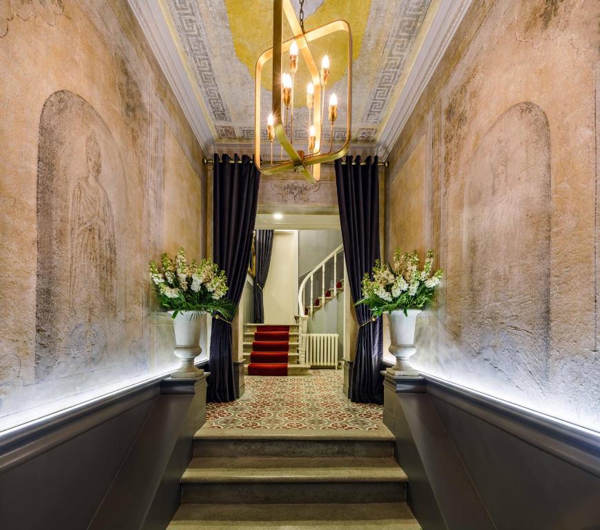 a hallway with a chandelier and stairs with flowers at The Soul Istanbul Hotel in Istanbul