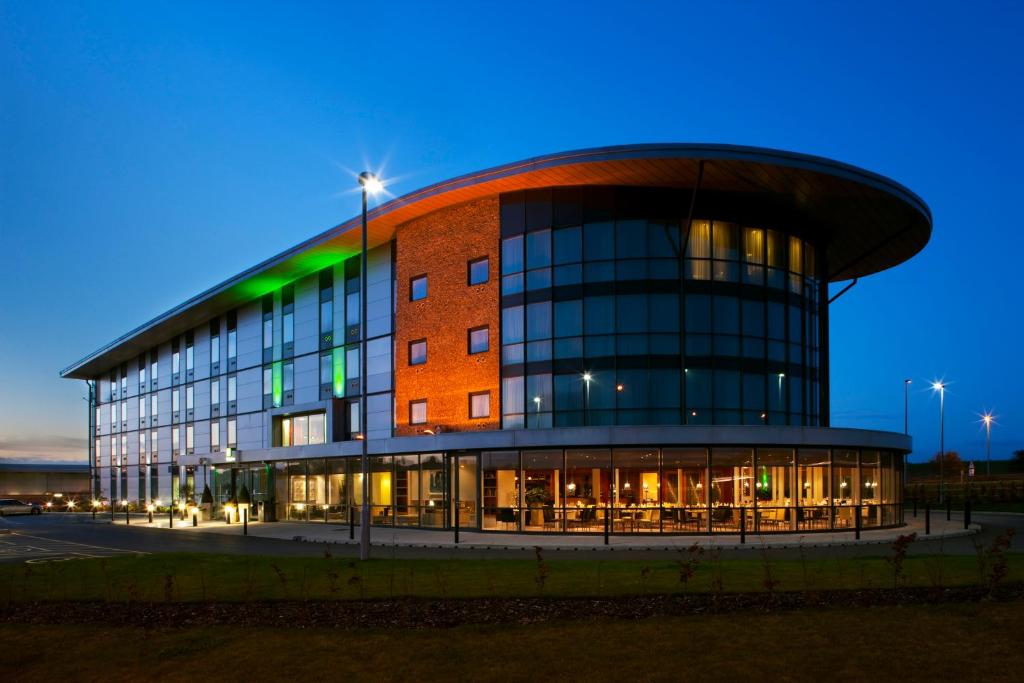 un gran edificio con un edificio por la noche en Holiday Inn Salisbury - Stonehenge, an IHG Hotel, en Salisbury