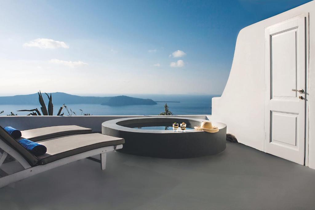 a hot tub on the balcony of a house at Remezzo Villas in Imerovigli