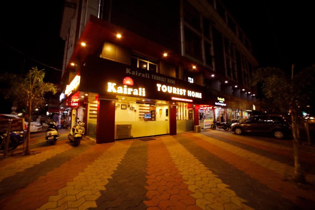 a building on a street at night with at Kairali Tourist Home in Guruvāyūr