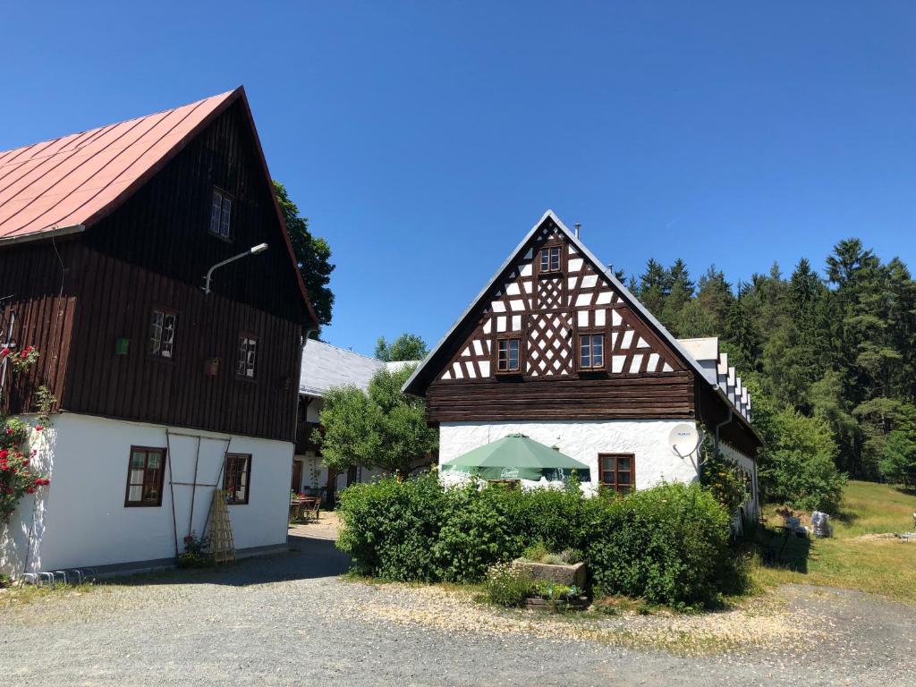 kilka budynków z drzewami w tle w obiekcie Pension Untere Rauner Muehle w mieście Bad Brambach