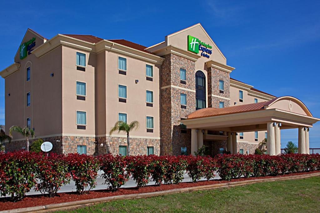 ein Hotel mit roten Blumen vor einem Gebäude in der Unterkunft Holiday Inn Express Texas City, an IHG Hotel in Texas City