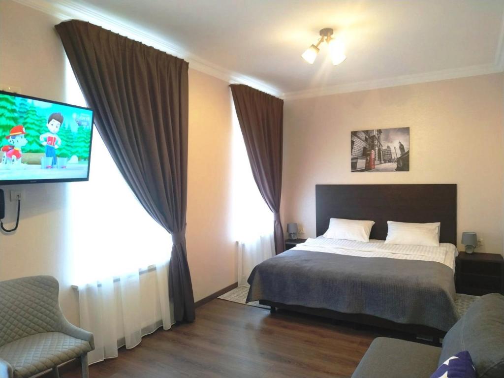 een slaapkamer met een bed en een flatscreen-tv bij Hotel Business Apartments in Dnipro