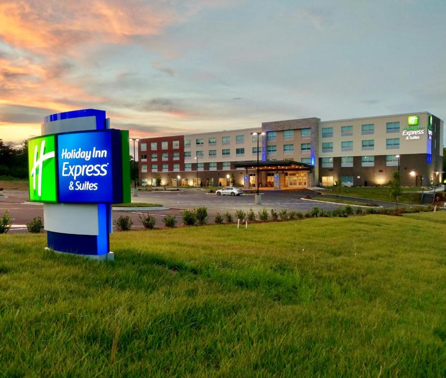 Holiday Inn Express & Suites Raleigh Airport - Brier Creek, an IHG Hotel في رالي: مبنى مستشفى مع وجود علامة في العشب