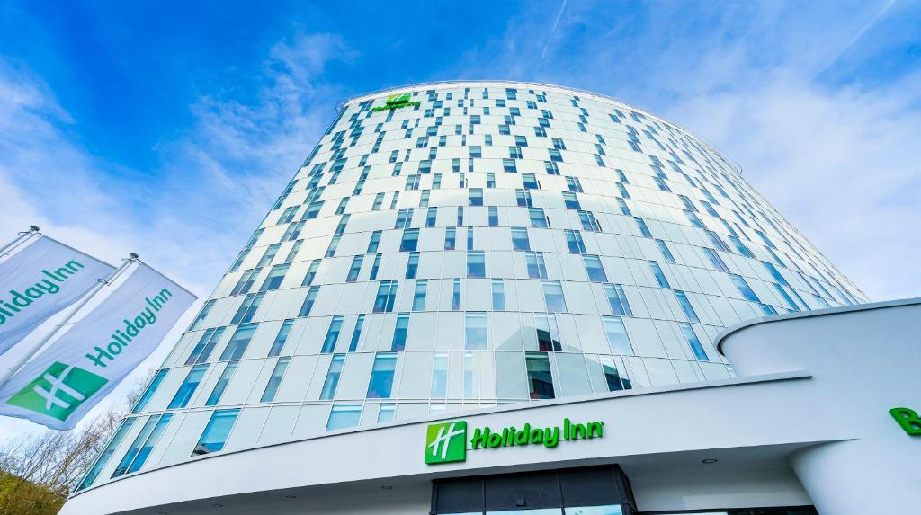 wysoki budynek z znakiem przed nim w obiekcie Holiday Inn Hamburg - City Nord, an IHG Hotel w mieście Hamburg