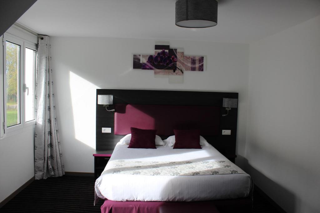 A bed or beds in a room at The Originals City Hôtel, Aéroport Beauvais