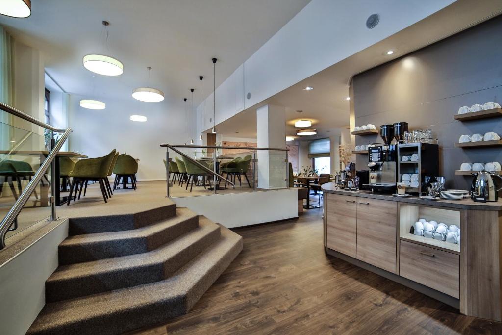 vestíbulo con escalera y cafetería en City Partner Hotel Berliner Hof, en Karlsruhe