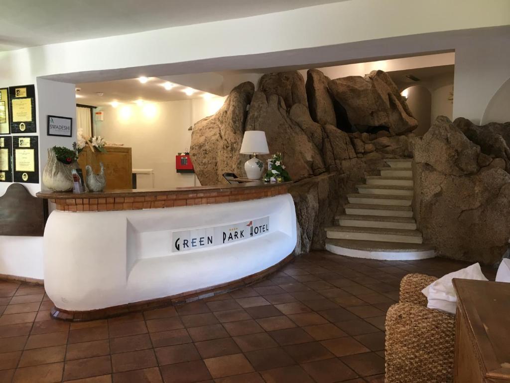 a lobby with a large rock wall and stairs at Green Park Hotel in Porto Cervo