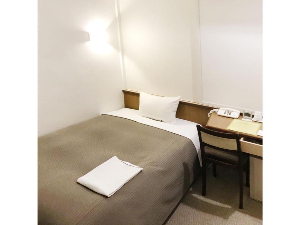 um pequeno quarto com uma cama e uma secretária em Grand Park Hotel Excel Fukushima Ebisu / Vacation STAY 77710 em Fukushima