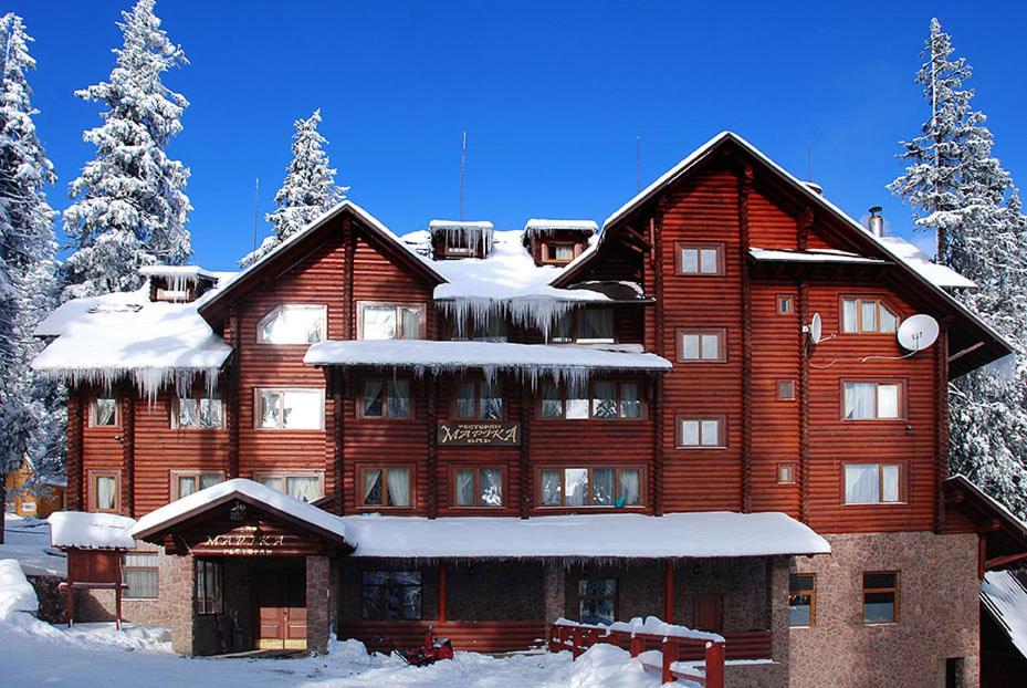 ein großes Holzgebäude mit Schnee darauf in der Unterkunft Marika in Drahobrat