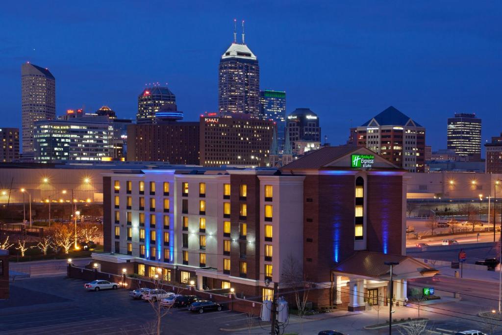 un edificio di fronte a uno skyline della città di notte di Holiday Inn Express Hotel & Suites Indianapolis Dtn-Conv Ctr, an IHG Hotel a Indianapolis