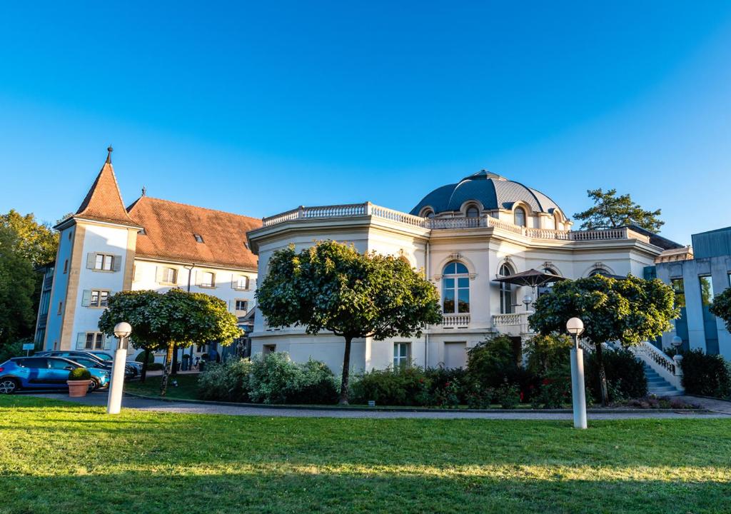 un grande edificio bianco con una cupola sopra di Grand Hotel et Centre Thermal d'Yverdon-les-Bains a Yverdon-les-Bains