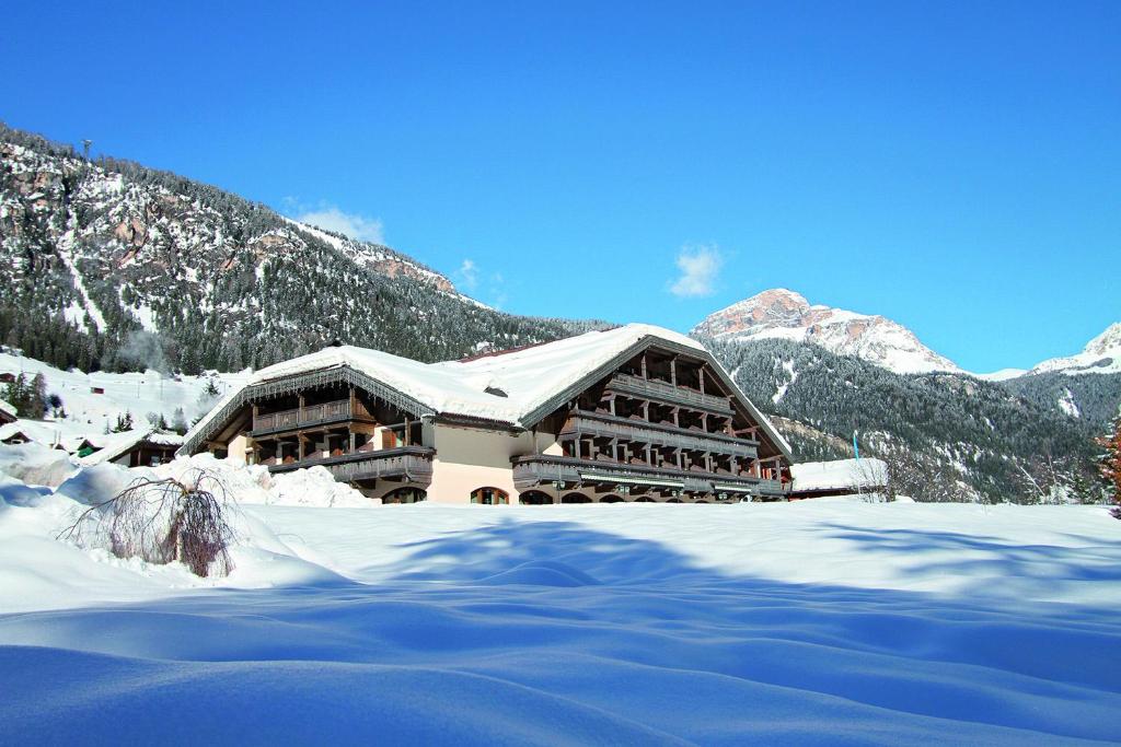 カンピテッロ・ディ・ファッサにあるHotel Rubino Deluxeの雪山を背景にした建物