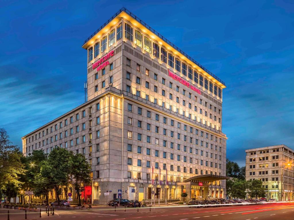 Un grand bâtiment avec des lumières sur son côté dans l'établissement Mercure Warszawa Grand, à Varsovie