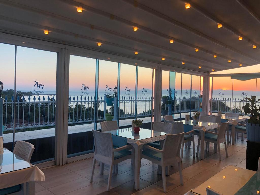 - un restaurant avec des tables et des chaises et une vue sur l'océan dans l'établissement Aura Boutique Hotel, à Sidé