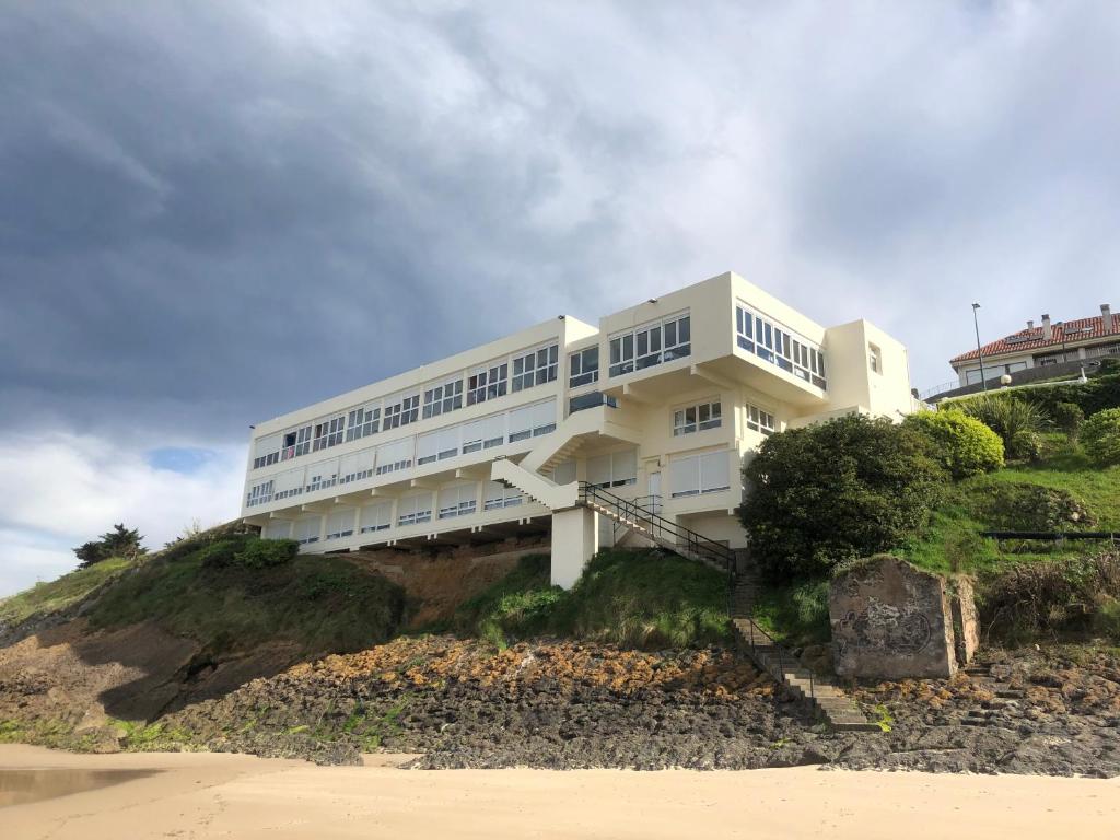 柯米拉斯Hotel Josein的海滩旁小山上的白色建筑