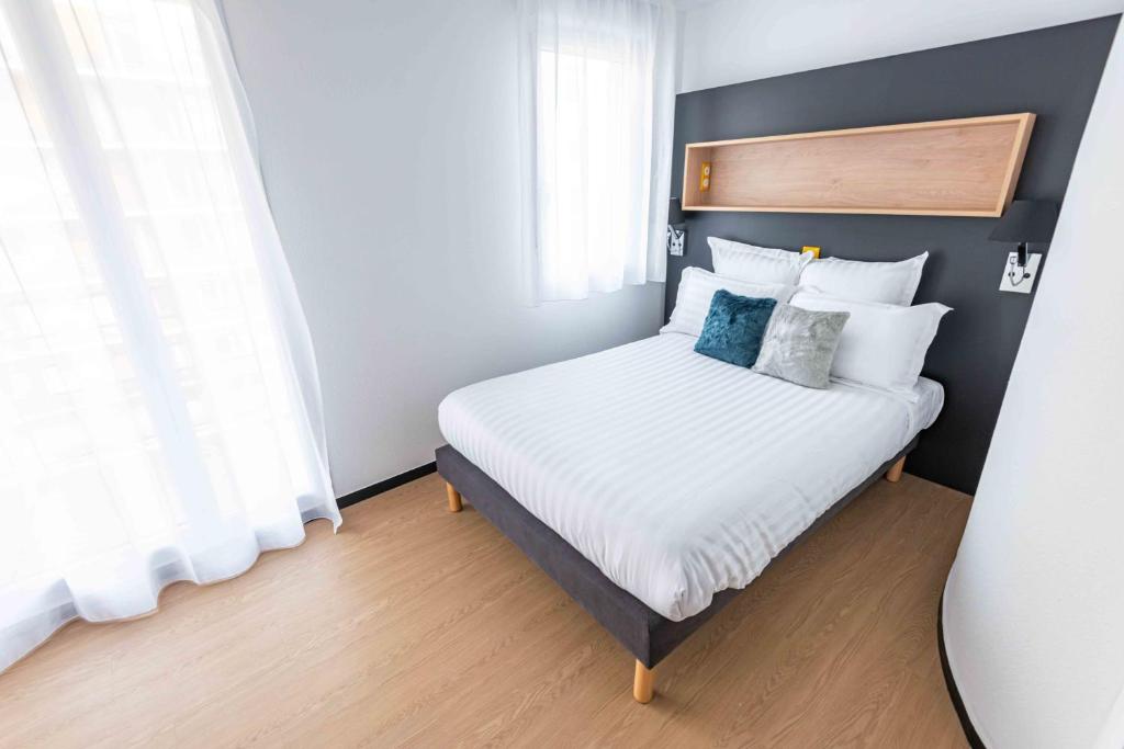 Giường trong phòng chung tại Apparthotel Le Hüb Grenoble