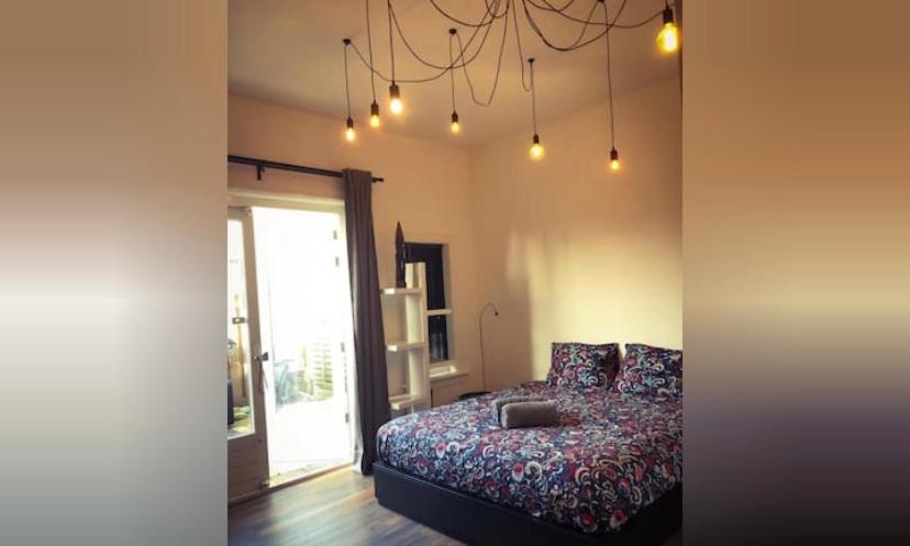 a bedroom with a bed and a chandelier at Queens Beachhouse in Zandvoort