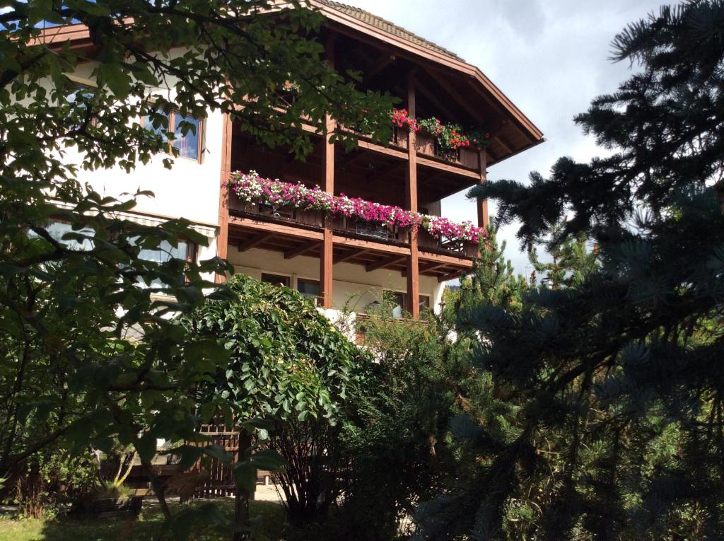 un edificio con un balcón con flores. en Residenze Sonnenschein Casa Bianca, en Villabassa