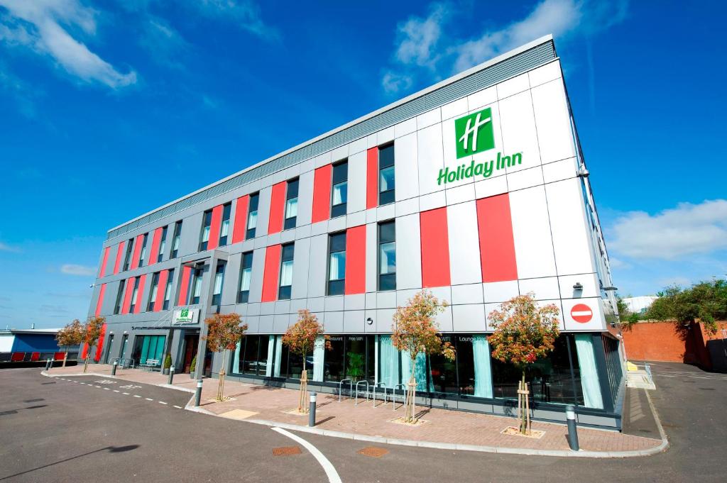 budynek z znakiem aptekowym na boku w obiekcie Holiday Inn London Luton Airport, an IHG Hotel w Luton