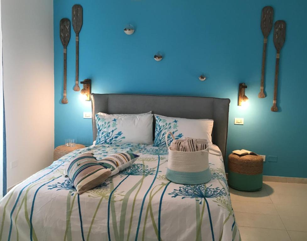 1 dormitorio con 1 cama con pared azul en Intra Rooms, en Olbia