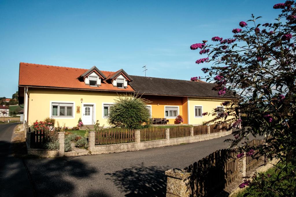 a yellow house with a fence in front of it at Gästehaus Ranftl in Unterlamm