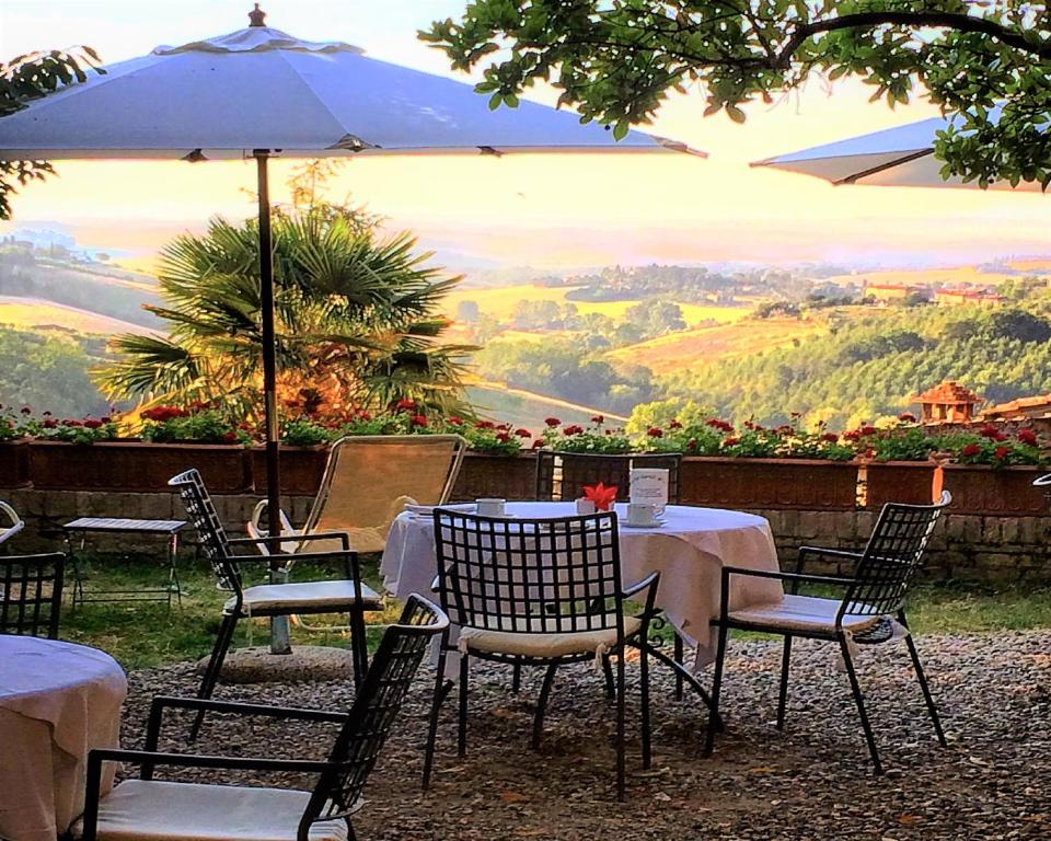 uma mesa com cadeiras e um guarda-sol com vista em Hotel Santa Caterina em Siena