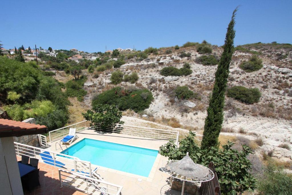 una casa con piscina accanto a una collina di Amoroza Villa a Pissouri