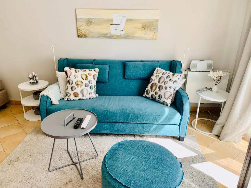 a living room with a blue couch and a table at Sellminchen Sylt in Westerland (Sylt)