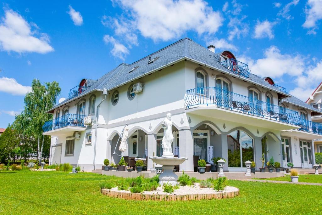 um grande edifício branco com uma fonte no quintal em Margret Haus em Balatonfüred