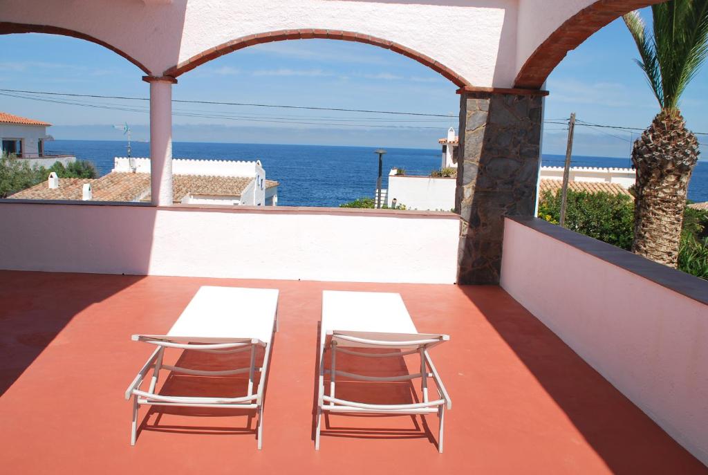 2 sedie e un tavolo sul balcone con vista sull'oceano di Es Caials a Cadaqués