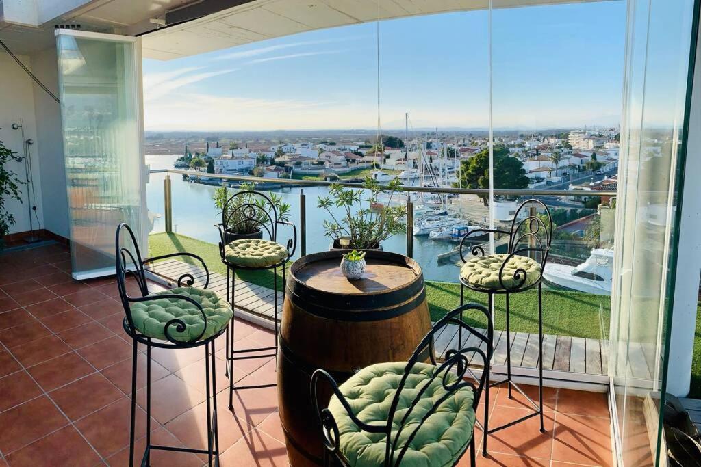 a balcony with a table and chairs and a large window at Les Marines in Roses