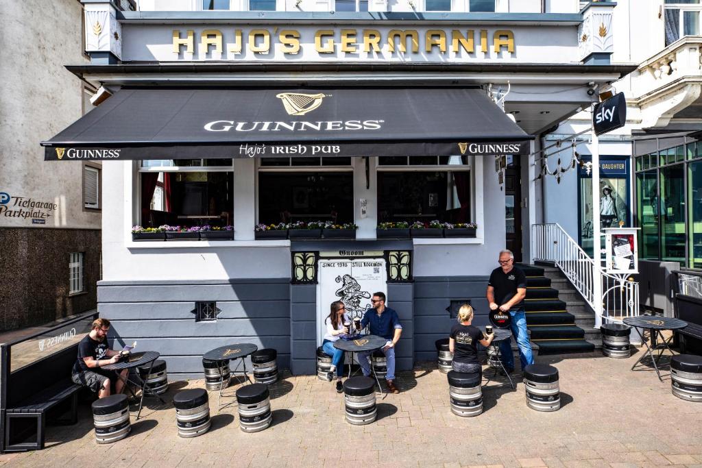 un gruppo di persone seduti ai tavoli fuori da un ristorante di Hajo´s Germania Lodge & Irish Pub a Rüdesheim am Rhein