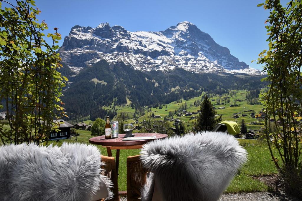 een tafel met stoelen en uitzicht op een berg bij Hotel Cabana in Grindelwald