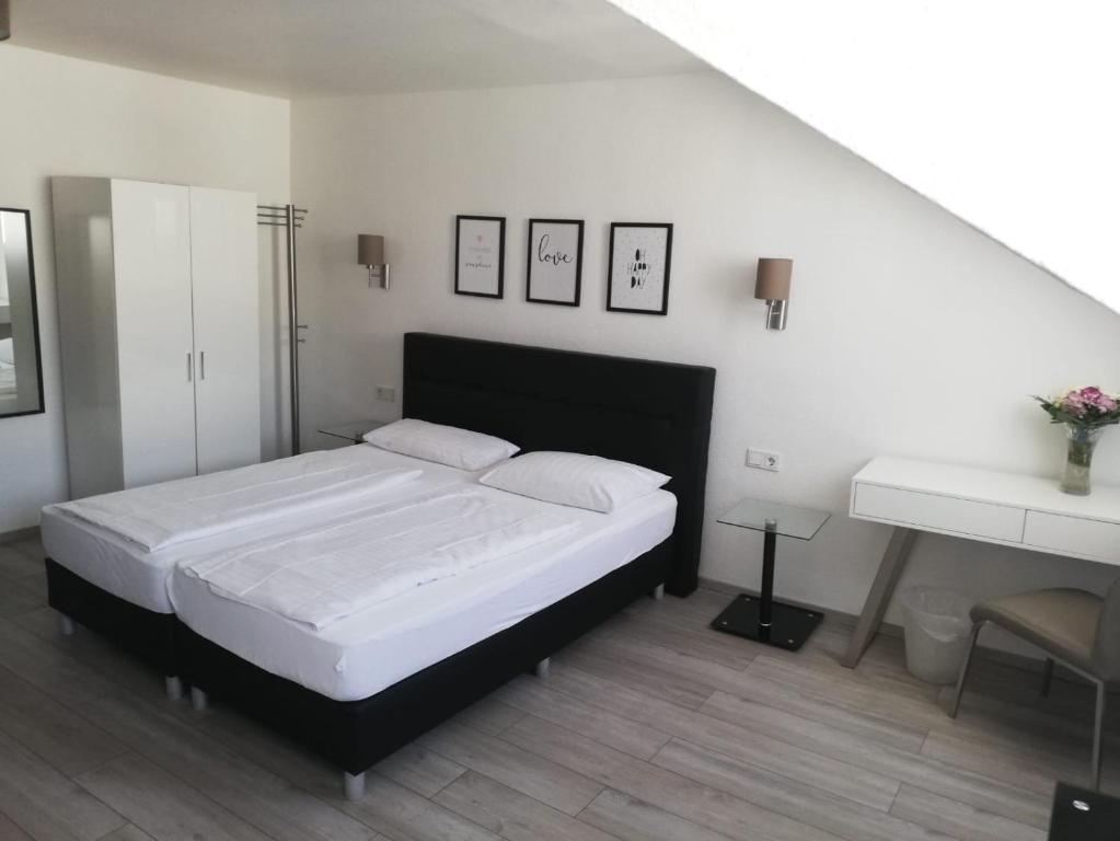 - une chambre avec un grand lit blanc et un bureau dans l'établissement Hotel Luisenhof, à Wiesbaden