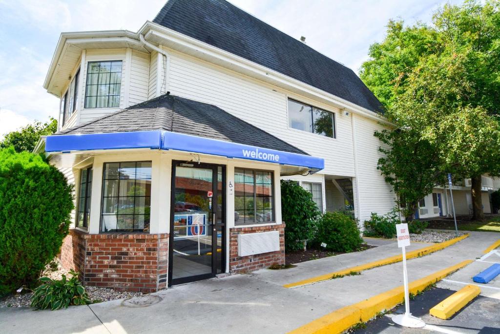 a building with a store with a blue awning at Motel 6-Wethersfield, CT - Hartford in Wethersfield