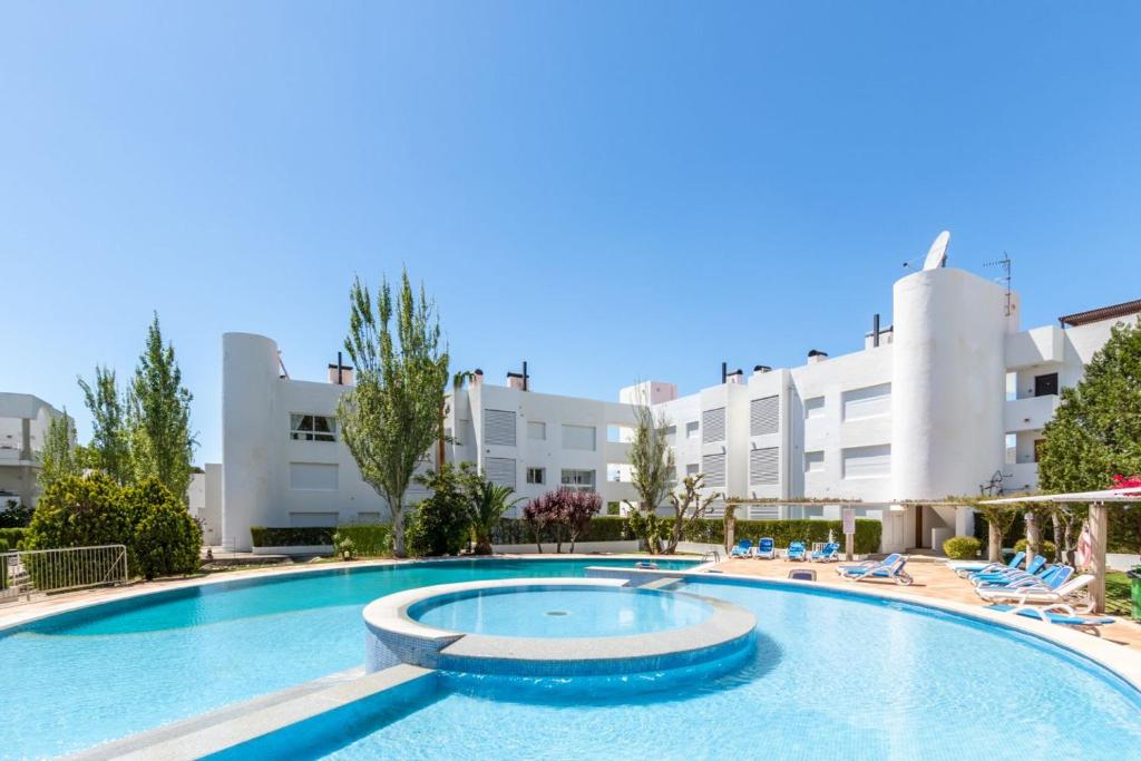 une grande piscine en face d'un bâtiment dans l'établissement Ground Floor with private garden Bellresguard, à Port de Pollença