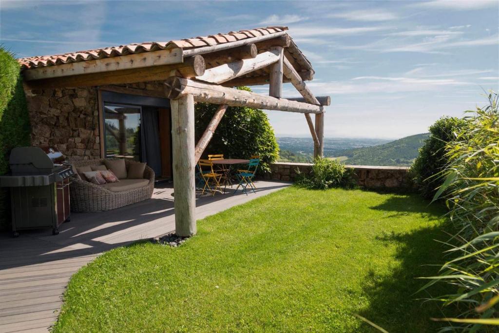 einen Hinterhof mit einer Holzterrasse mit einer Pergola in der Unterkunft La Chomotte in Saint-Alban-dʼAy