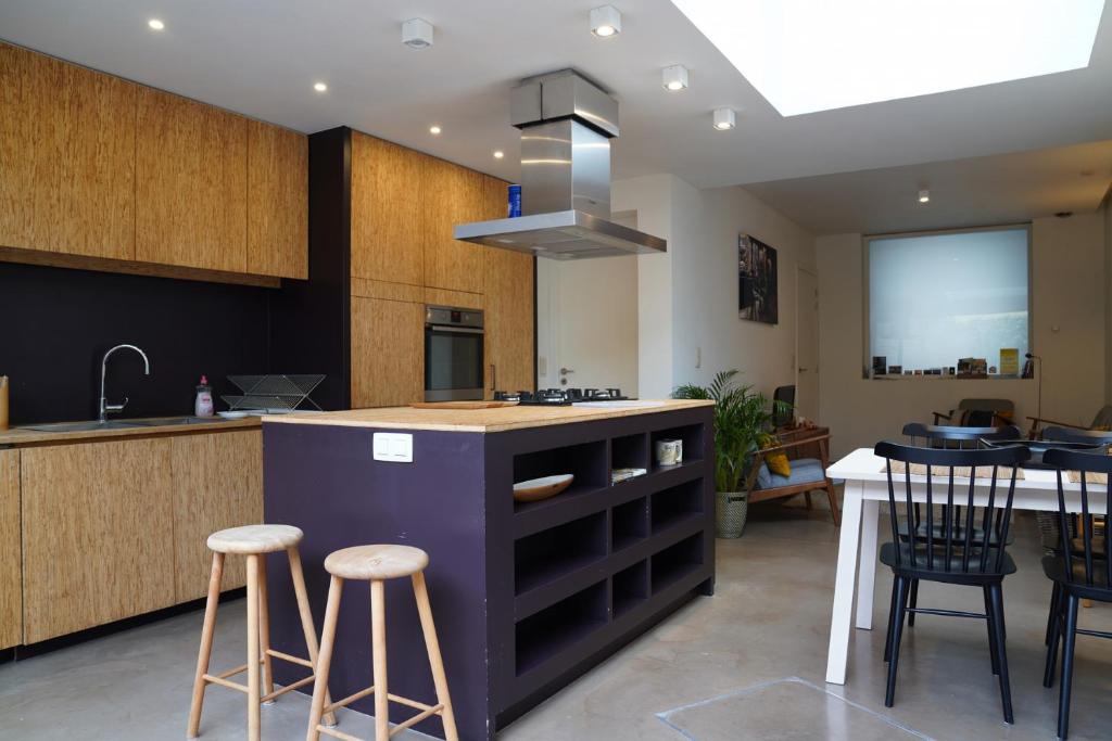 uma cozinha com uma ilha com bancos de bar e uma mesa em Well-situated and Comfortable Home em Gante