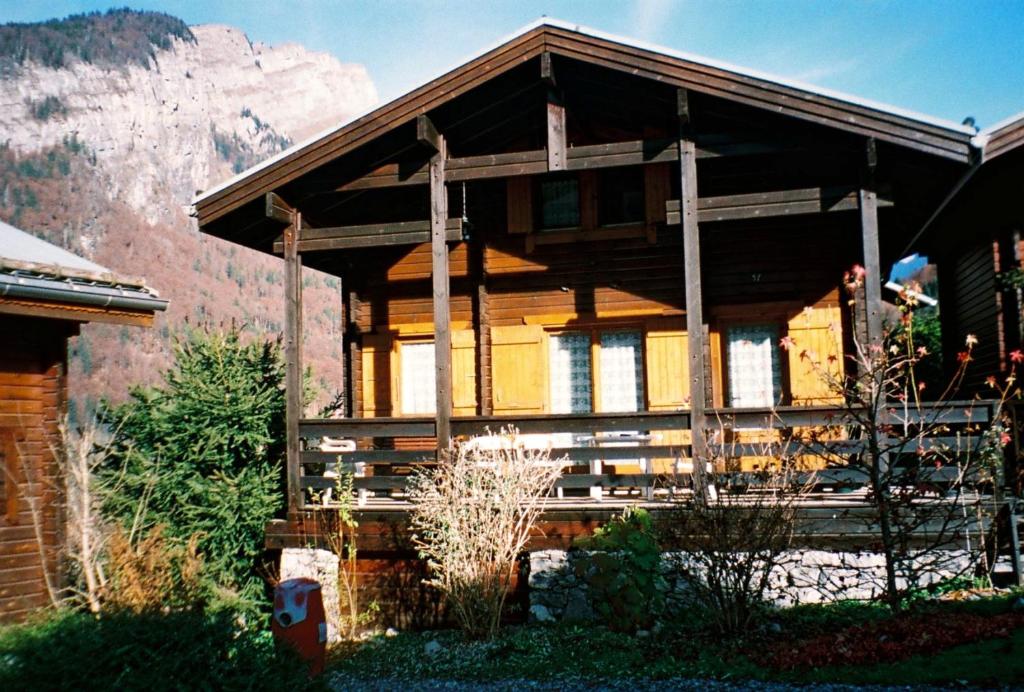 ein Holzhaus mit einem Berg im Hintergrund in der Unterkunft Chalet cosy a Sixt Fer a Cheval avec vue sur la montagne in Sixt