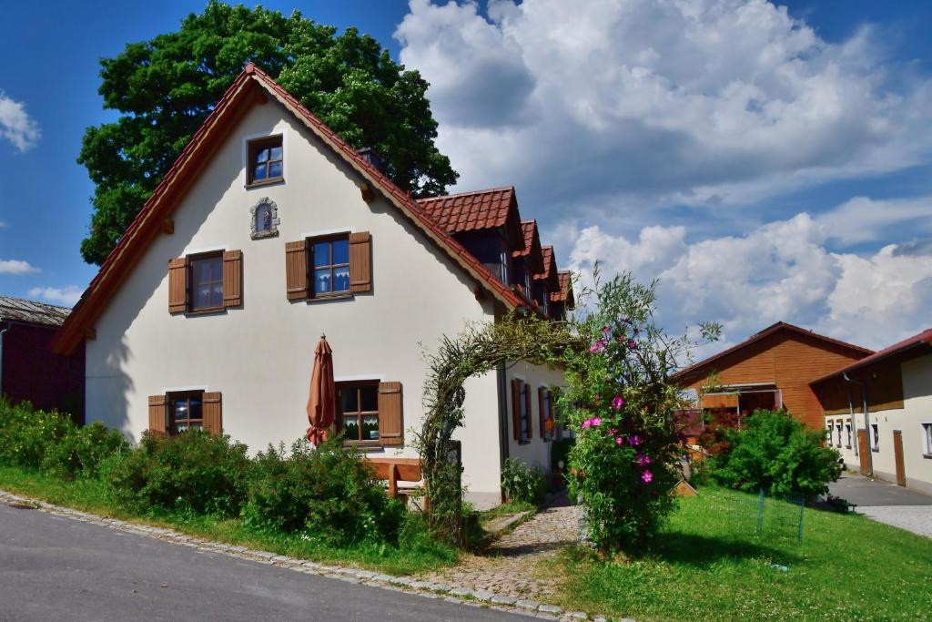 Biały dom z brązowymi oknami i dziedzińcem w obiekcie Ferienwohnung Burgerhof w mieście Pullenreuth