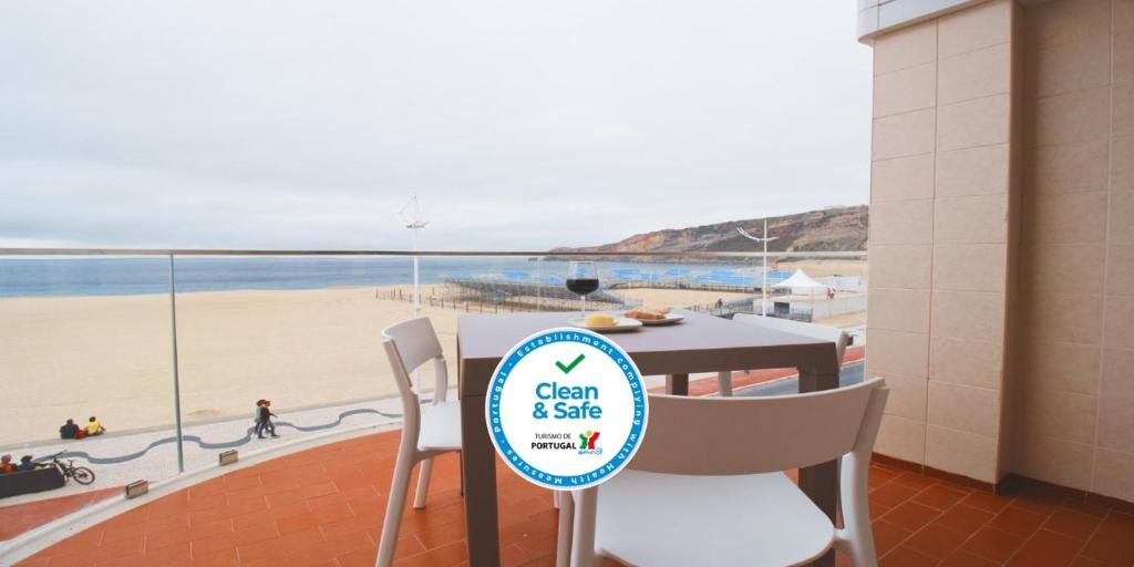 a table and chairs with a view of a beach at Holidays Nazaré marginal in Nazaré