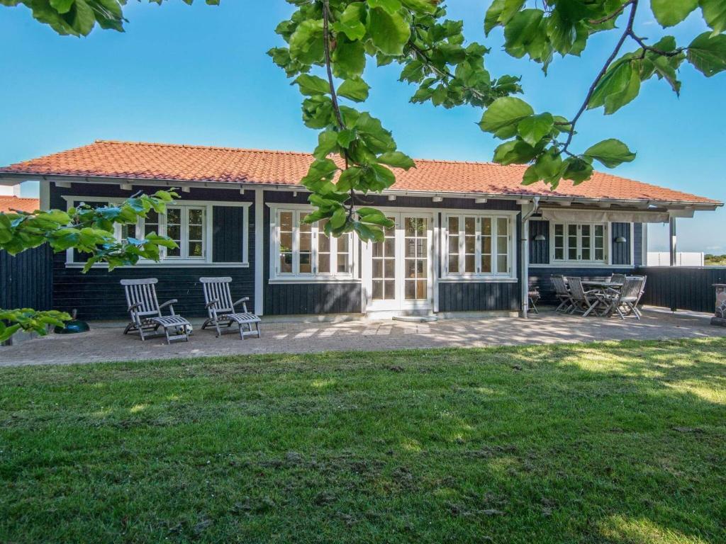 a house with chairs in front of a yard at Holiday Home Sandskærvej II in Aabenraa