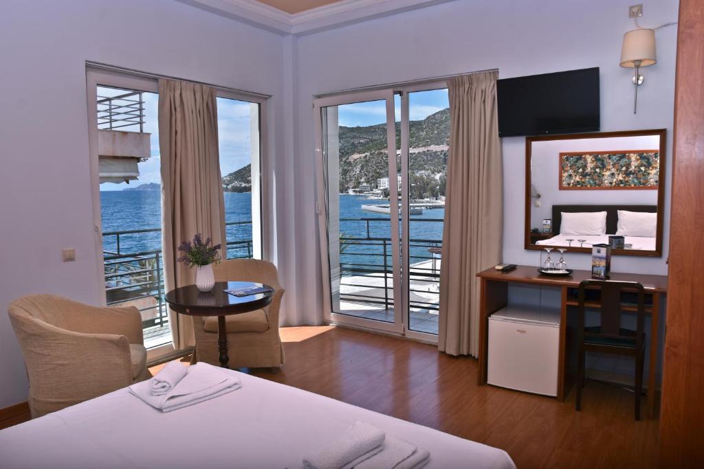 Cette chambre d'hôtel comprend un lit et un bureau avec vue sur l'océan. dans l'établissement Grand Hotel Loutraki, à Loutraki