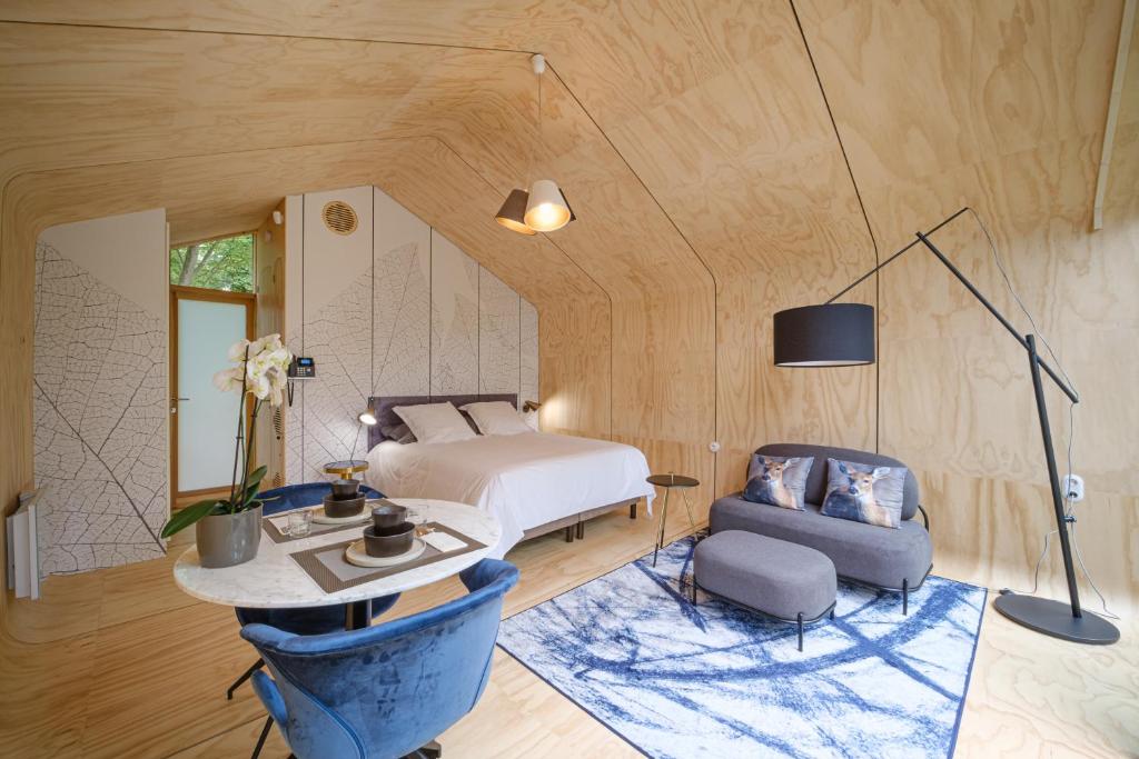 a bedroom with a bed and a table and a chair at Domaine de la Résidence - Hôtel, Spa & Restaurant in Moulins-lès-Metz