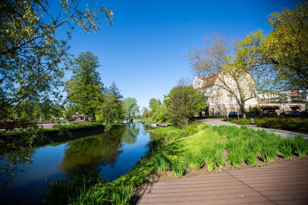 uma vista para um rio com edifícios e árvores em Apartament Masuria em Ełk